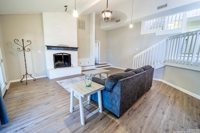 living room with visible vents, baseboards, and wood finished floors