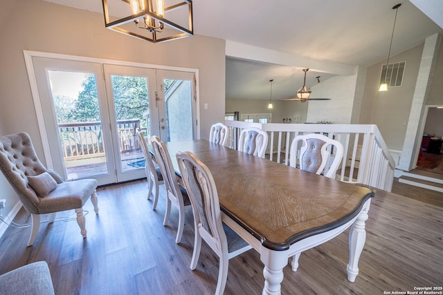 dining area featuring french doors, visible vents, wood finished floors, and vaulted ceiling with beams