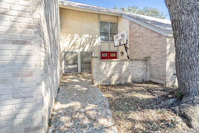 back of property with brick siding and stucco siding