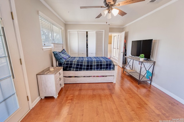 bedroom featuring light wood-style flooring, baseboards, a closet, and ornamental molding