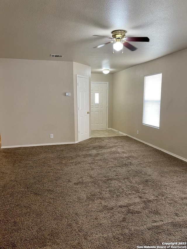 unfurnished room featuring visible vents, a textured ceiling, ceiling fan, and carpet flooring