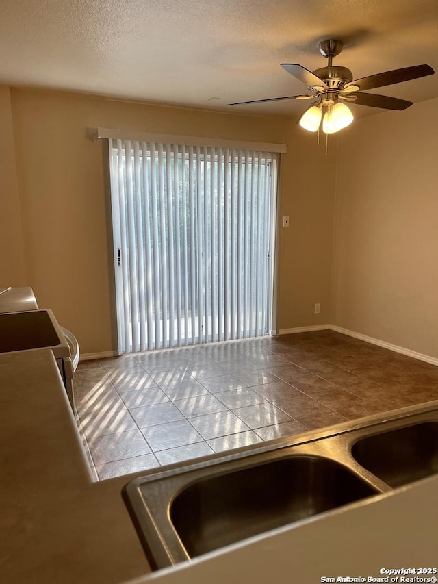 kitchen with a ceiling fan, a textured ceiling, white electric range oven, tile patterned flooring, and baseboards