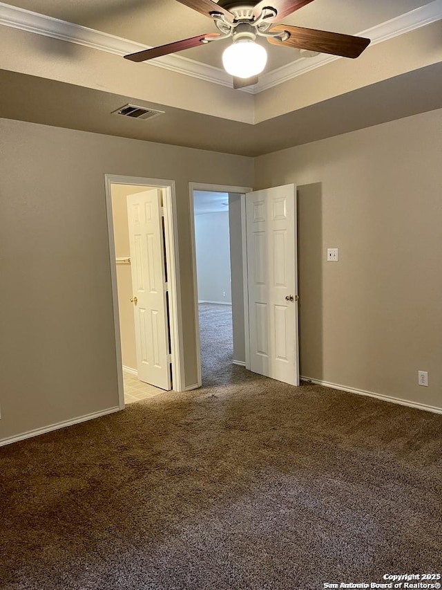 spare room with visible vents, a raised ceiling, light colored carpet, and a ceiling fan