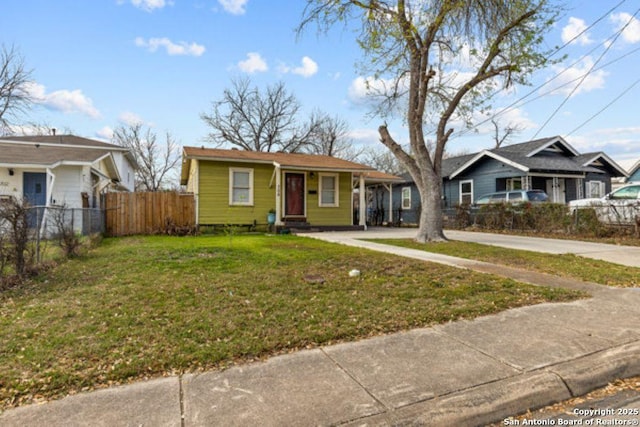 view of front of property with entry steps, concrete driveway, a front yard, and fence