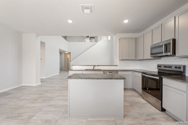 kitchen featuring visible vents, ceiling fan, decorative backsplash, dark stone countertops, and appliances with stainless steel finishes