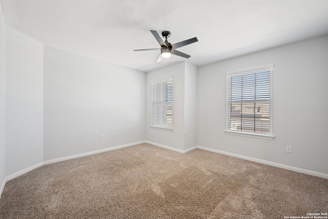 carpeted empty room featuring baseboards and ceiling fan