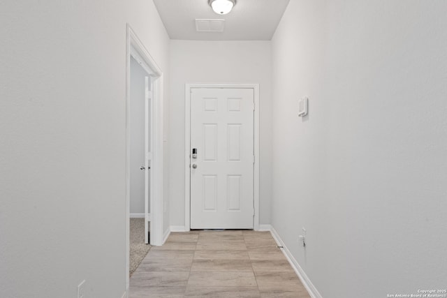 hallway with visible vents and baseboards