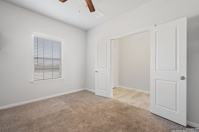 unfurnished bedroom with baseboards, light carpet, and a ceiling fan