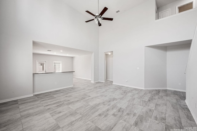 unfurnished living room featuring visible vents, baseboards, and a ceiling fan