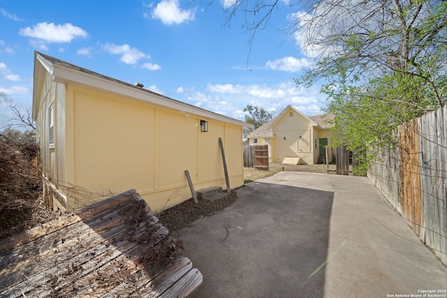 view of property exterior featuring a patio and fence