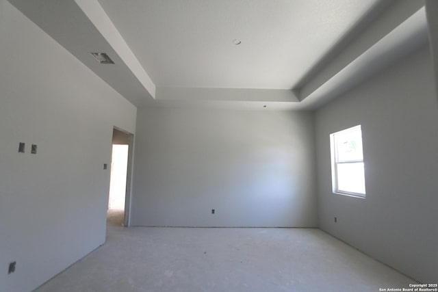 empty room featuring a tray ceiling and visible vents