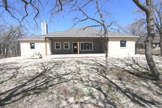 rear view of house with a patio and a chimney