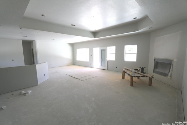 unfurnished living room featuring visible vents, a fireplace, and a raised ceiling