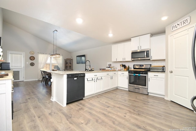 kitchen featuring stainless steel appliances, a peninsula, and white cabinetry