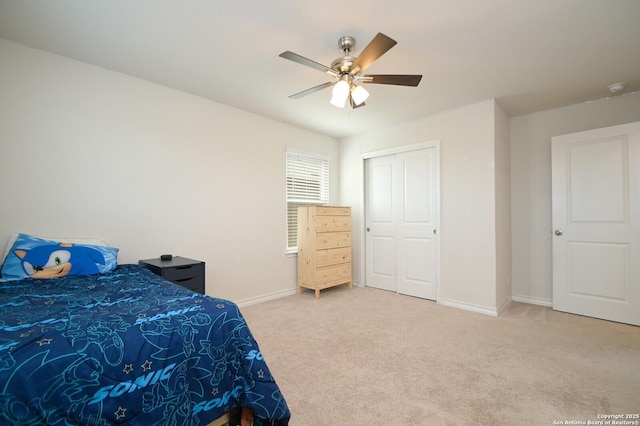 carpeted bedroom featuring a closet, ceiling fan, and baseboards