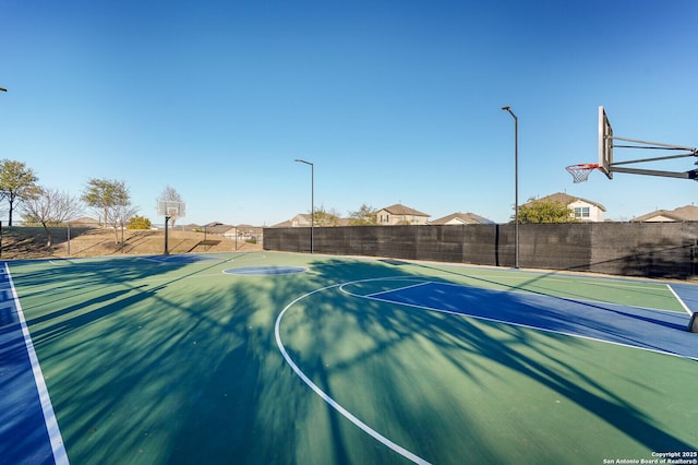 view of basketball court with community basketball court and fence