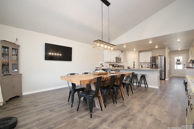 dining area featuring recessed lighting, high vaulted ceiling, baseboards, and wood finished floors