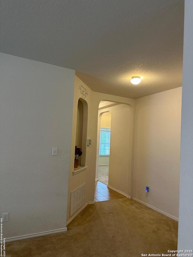 6754 Indian Ldg, San Antonio, TX 78253 - carpeted spare room with arched walkways, a textured ceiling, and baseboards