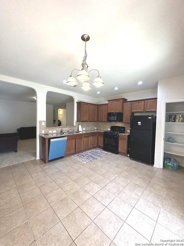 kitchen with pendant lighting, black appliances, tasteful backsplash, arched walkways, and a chandelier