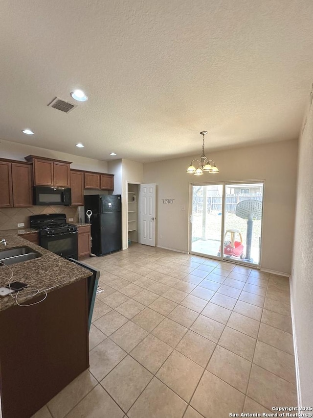 kitchen featuring visible vents, black appliances, a sink, light tile patterned floors, and a chandelier