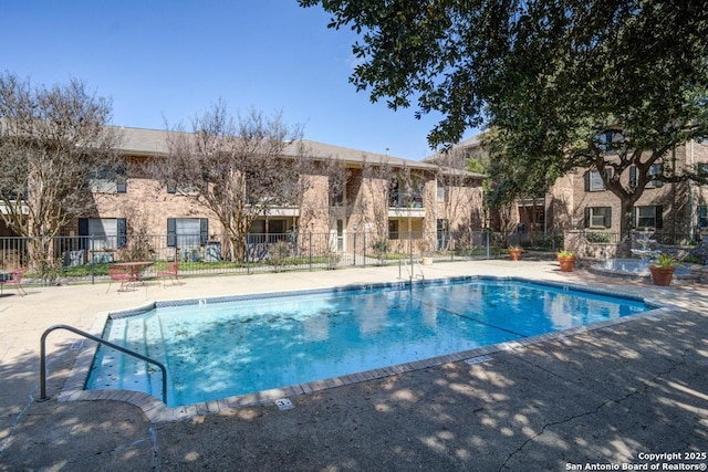 view of swimming pool featuring a patio area and fence