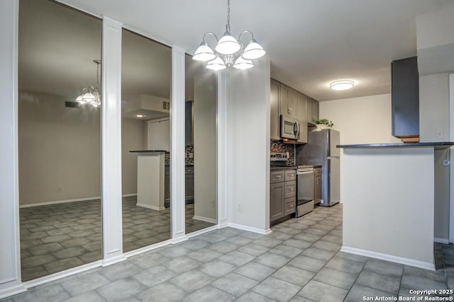 kitchen featuring visible vents, gray cabinets, stainless steel appliances, tasteful backsplash, and a chandelier