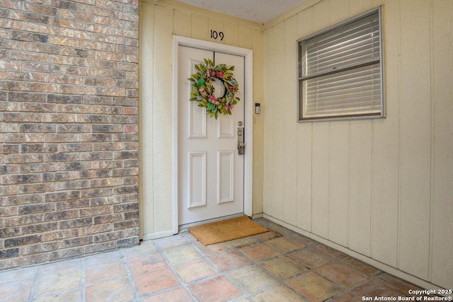 entrance to property featuring brick siding