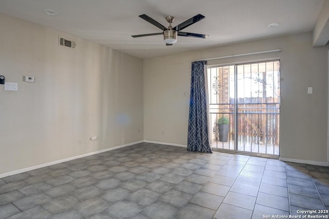 spare room featuring baseboards, visible vents, and ceiling fan