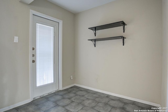 doorway to outside featuring baseboards