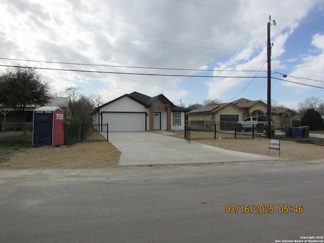 ranch-style house with a garage, driveway, and a fenced front yard