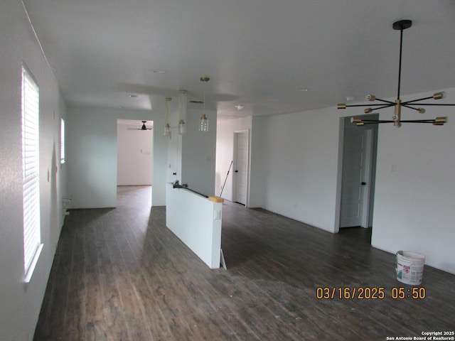 spare room featuring a chandelier and dark wood-type flooring