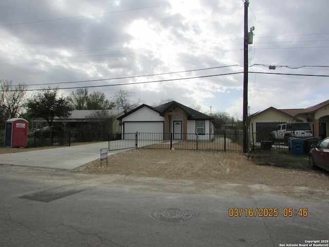 view of front of house with a fenced front yard, concrete driveway, and an attached garage