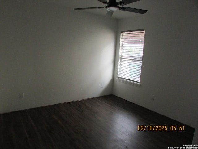 empty room with dark wood-type flooring and ceiling fan