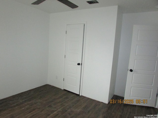 unfurnished room featuring dark wood-style floors, visible vents, and ceiling fan