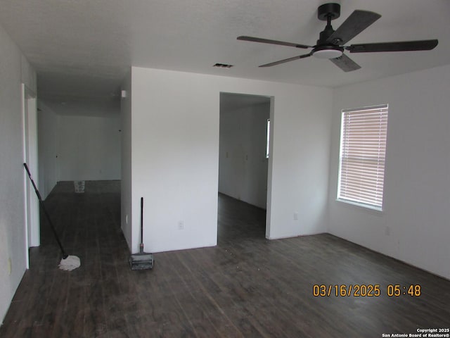 empty room featuring visible vents, wood finished floors, and a ceiling fan