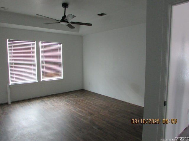 unfurnished room featuring visible vents, a ceiling fan, and wood finished floors