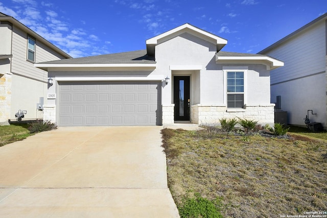 view of front of house featuring a garage, stone siding, driveway, and stucco siding