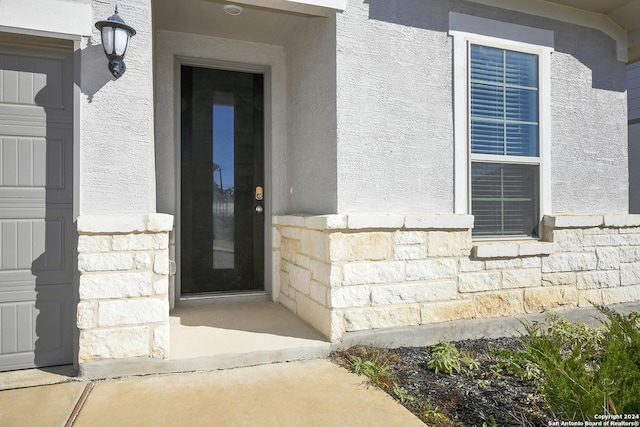 entrance to property with stucco siding and stone siding