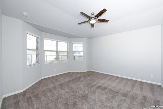 spare room with vaulted ceiling, baseboards, carpet floors, and ceiling fan