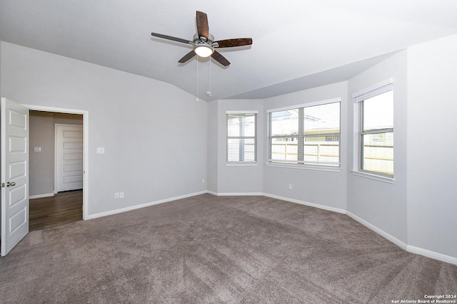 empty room with carpet flooring, baseboards, ceiling fan, and vaulted ceiling