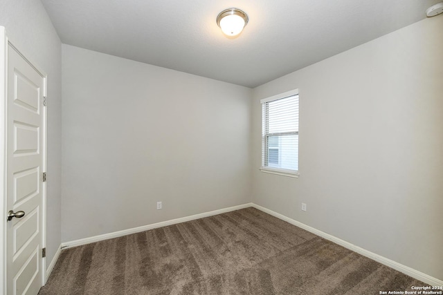 spare room featuring baseboards and carpet floors