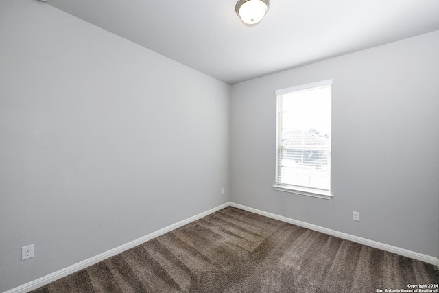 empty room featuring baseboards and carpet