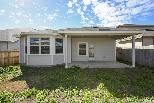 back of property featuring a patio area, a lawn, and a fenced backyard