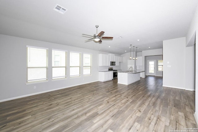 unfurnished living room with visible vents, baseboards, a ceiling fan, and wood finished floors