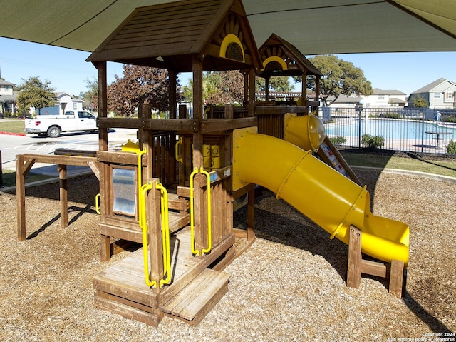 communal playground featuring a residential view and fence