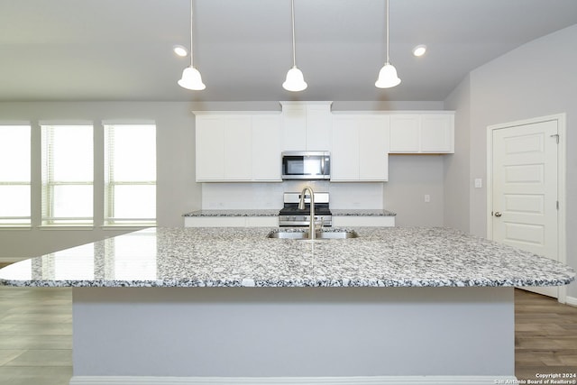 kitchen featuring white cabinets, a kitchen island with sink, appliances with stainless steel finishes, and a sink