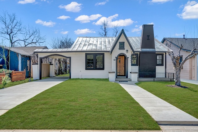 view of front of house featuring driveway, a front lawn, a standing seam roof, and metal roof