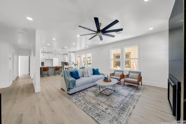 living area featuring recessed lighting, attic access, light wood-type flooring, and ceiling fan