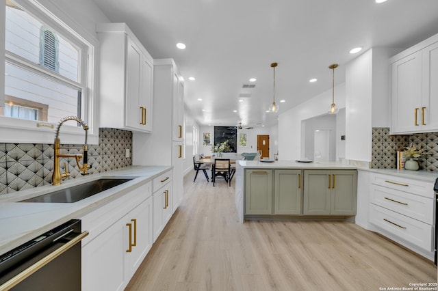 kitchen featuring a sink, light wood-style floors, dishwasher, and a wealth of natural light