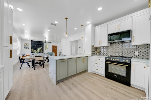 kitchen featuring decorative backsplash, stainless steel microwave, black / electric stove, and visible vents